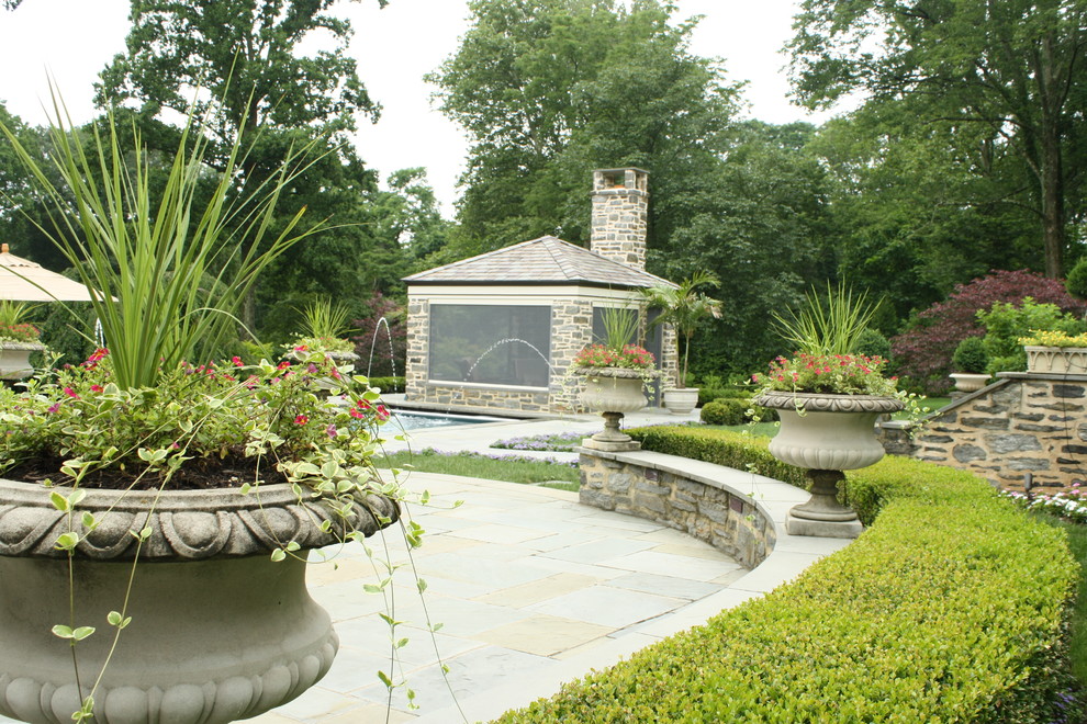 Immagine di un grande giardino formale chic esposto in pieno sole dietro casa con pavimentazioni in pietra naturale