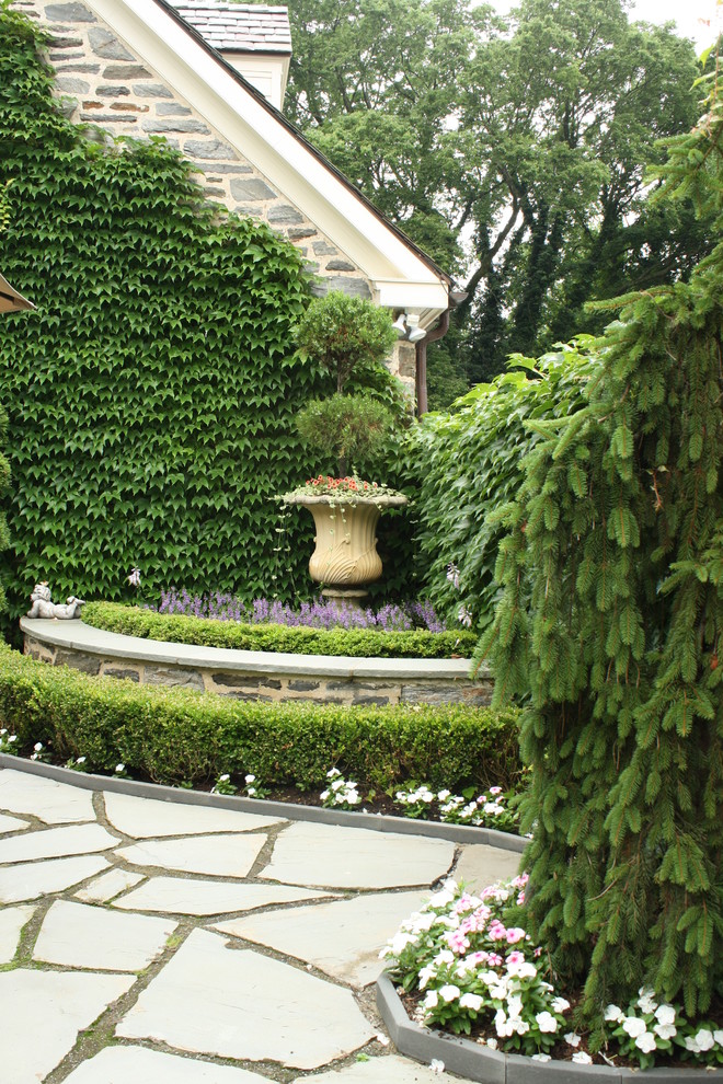 This is an example of a large traditional full sun backyard stone formal garden in Philadelphia.