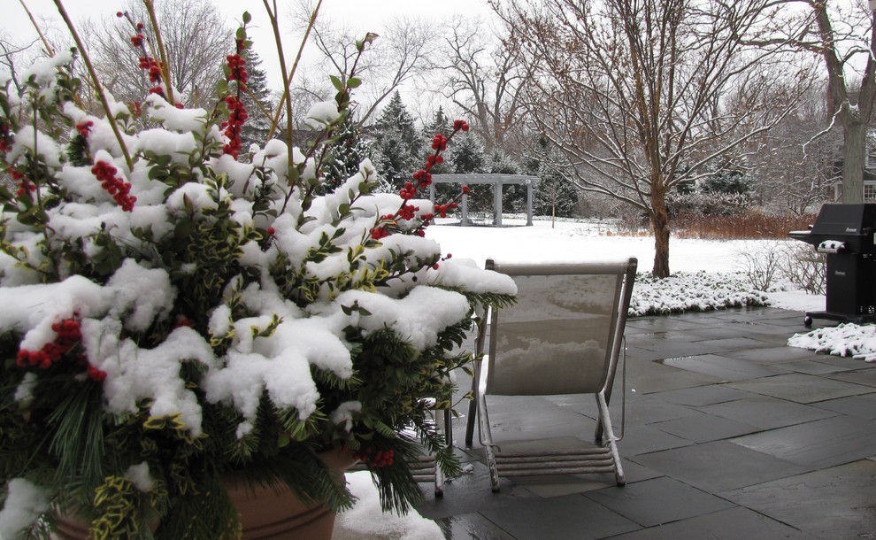 Imagen de jardín clásico grande en invierno en patio trasero con jardín de macetas, exposición total al sol y adoquines de piedra natural