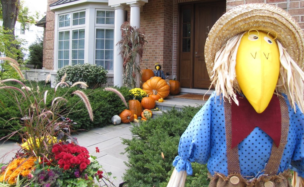 This is an example of a large traditional full sun front yard stone landscaping in Chicago for fall.