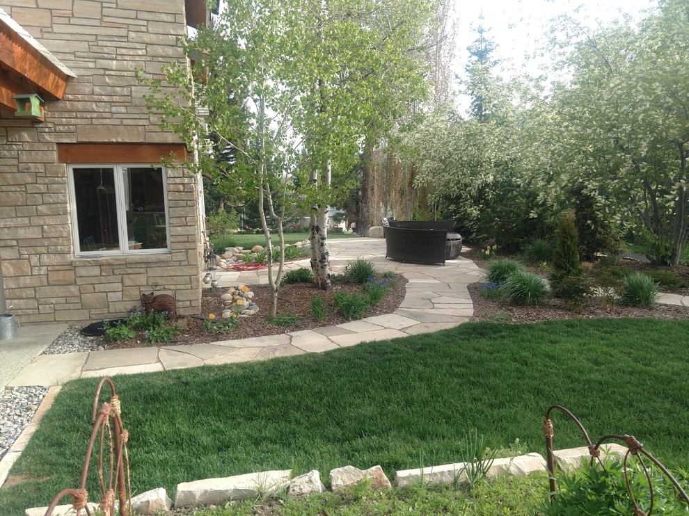 This is an example of a medium sized classic back garden in Denver with natural stone paving.