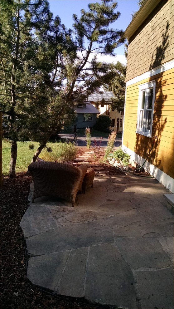 Modelo de jardín clásico de tamaño medio en patio lateral con adoquines de piedra natural