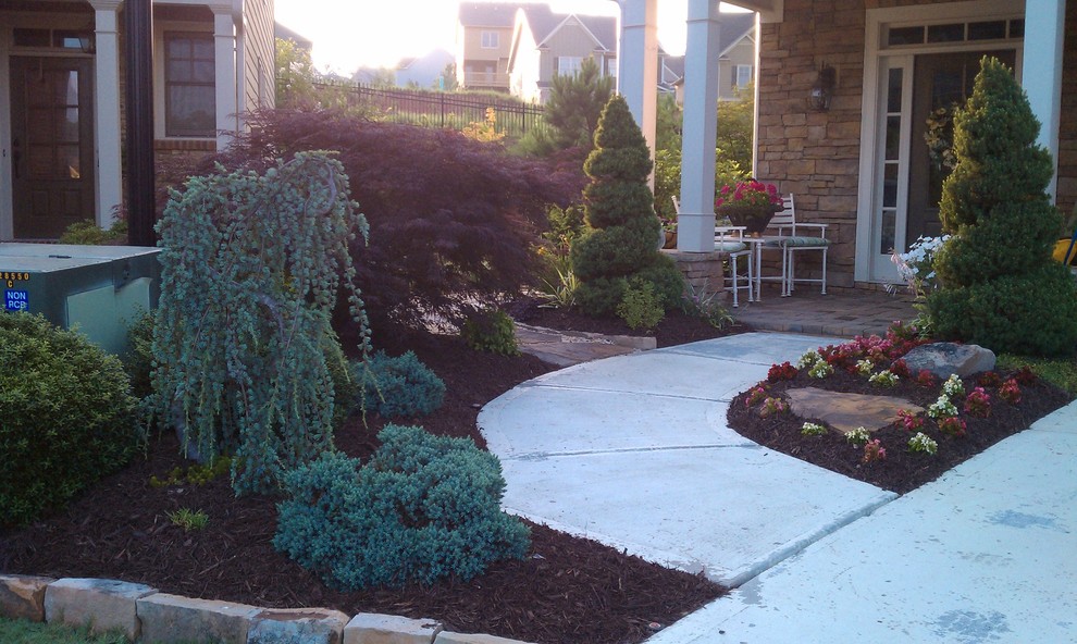 This is an example of a large traditional full sun front yard concrete paver landscaping in Atlanta for summer.