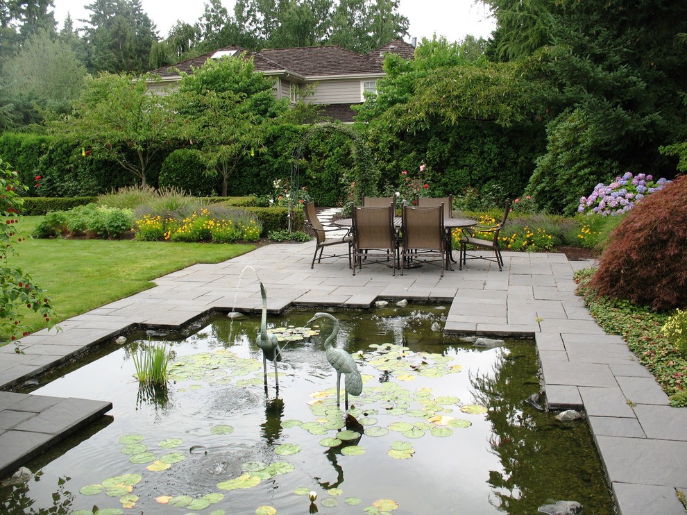 Klassischer Garten mit Wasserspiel und Betonboden in Seattle