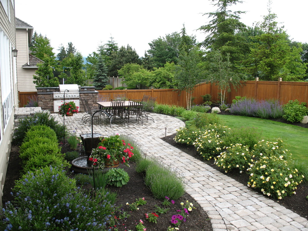 На фото: участок и сад в классическом стиле с мощением тротуарной плиткой