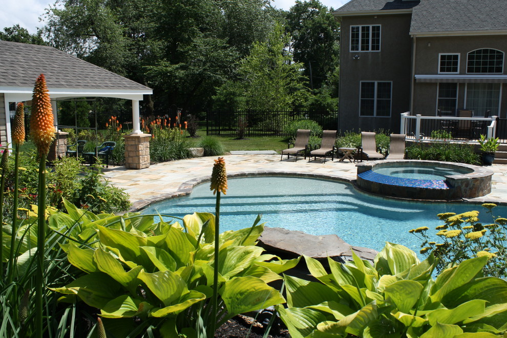 Foto di un giardino tropicale di medie dimensioni e dietro casa in estate con pavimentazioni in pietra naturale