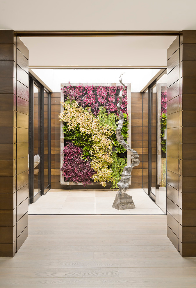 Photo of a small beach style courtyard full sun garden in Los Angeles with a living wall and natural stone paving.