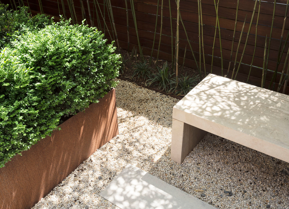 Immagine di un piccolo giardino moderno esposto a mezz'ombra dietro casa con un ingresso o sentiero e pavimentazioni in pietra naturale
