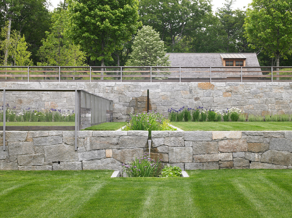 Idee per un giardino minimal esposto in pieno sole con un muro di contenimento