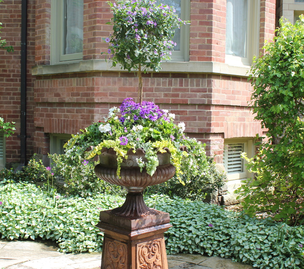 Источник вдохновения для домашнего уюта: большой регулярный сад на внутреннем дворе в классическом стиле с растениями в контейнерах и мощением тротуарной плиткой
