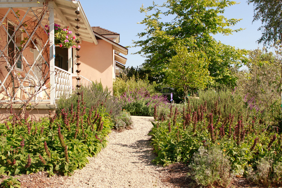 Idéer för en stor rustik trädgård i full sol framför huset på våren, med en trädgårdsgång och grus