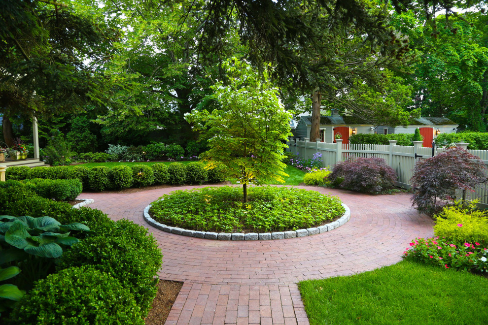 На фото: регулярный сад в классическом стиле с садовой дорожкой или калиткой и мощением клинкерной брусчаткой