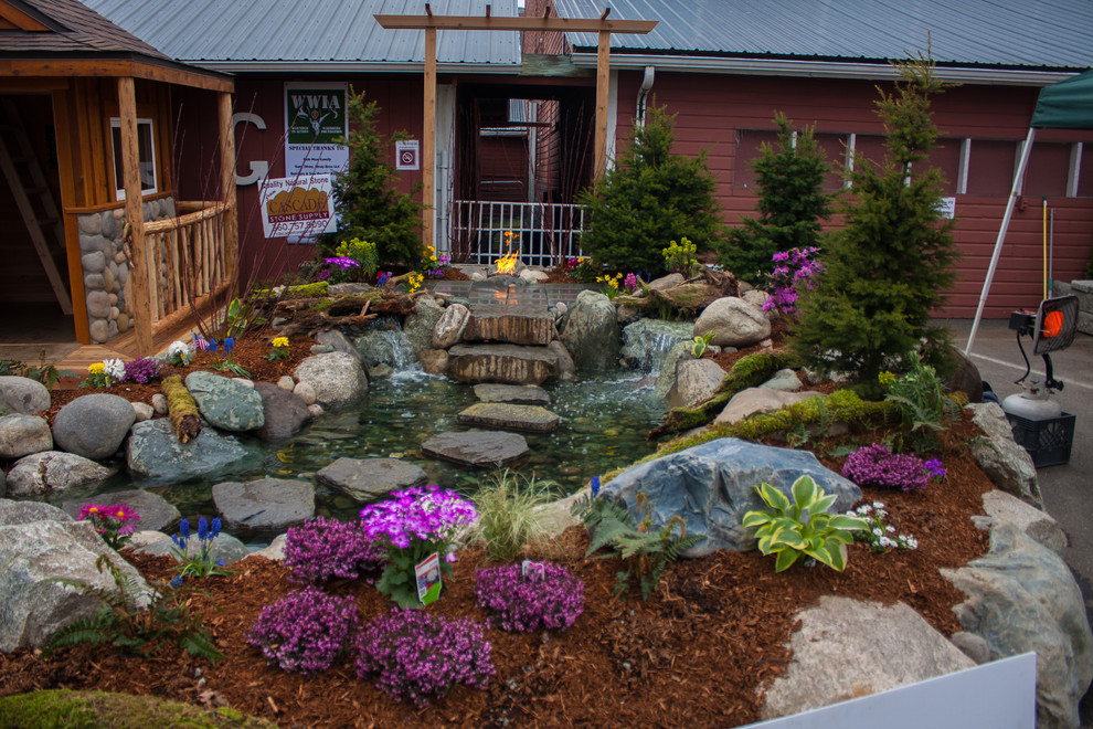 This is an example of a small rustic full sun side yard stone landscaping in Seattle for spring.