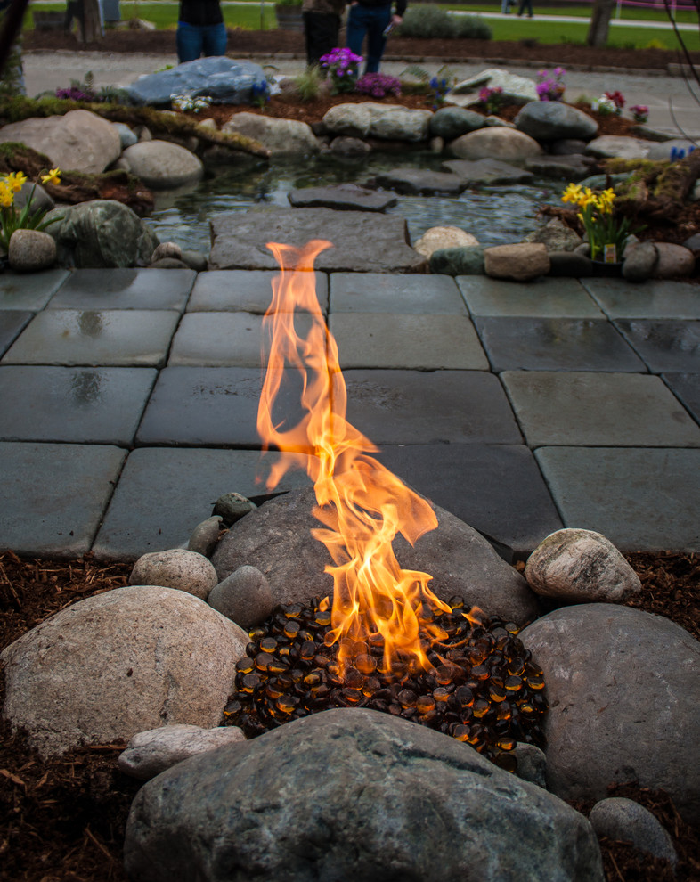 Design ideas for a small rustic side formal full sun garden for spring in Seattle with a fire feature and natural stone paving.