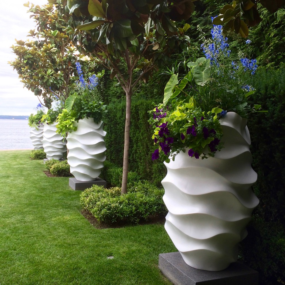 Immagine di un giardino formale minimalista esposto a mezz'ombra dietro casa e di medie dimensioni in estate con un giardino in vaso e pavimentazioni in cemento