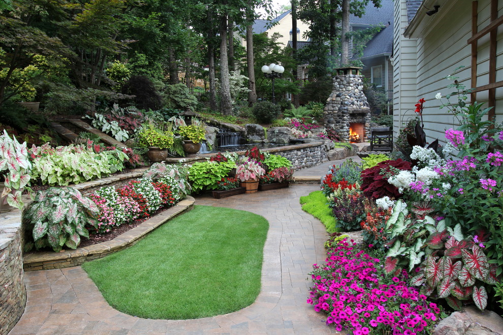 This is an example of a traditional back raised pond in Atlanta with brick paving.