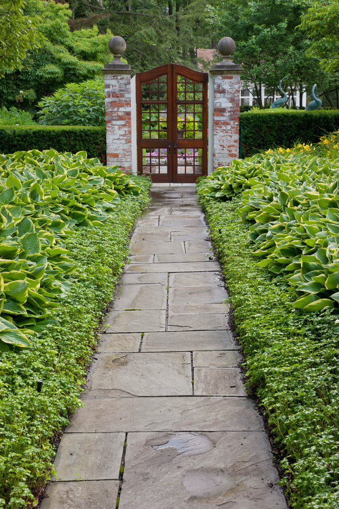 Пример оригинального дизайна: огромный регулярный сад на заднем дворе в классическом стиле с покрытием из каменной брусчатки
