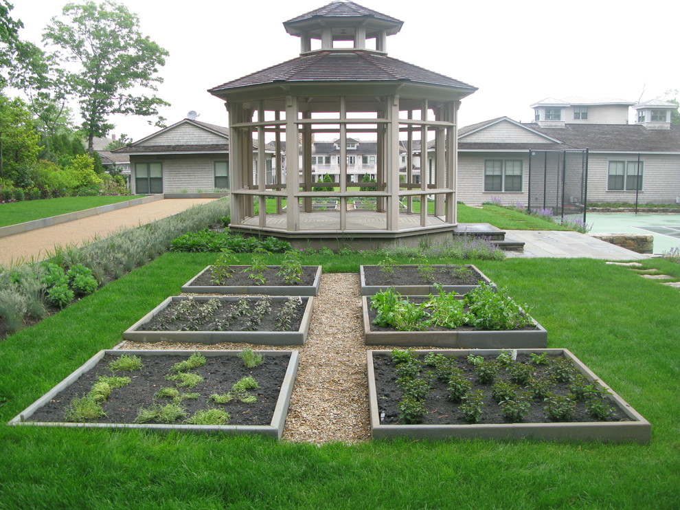 Large nautical back formal full sun garden in Boston with a vegetable patch and gravel.