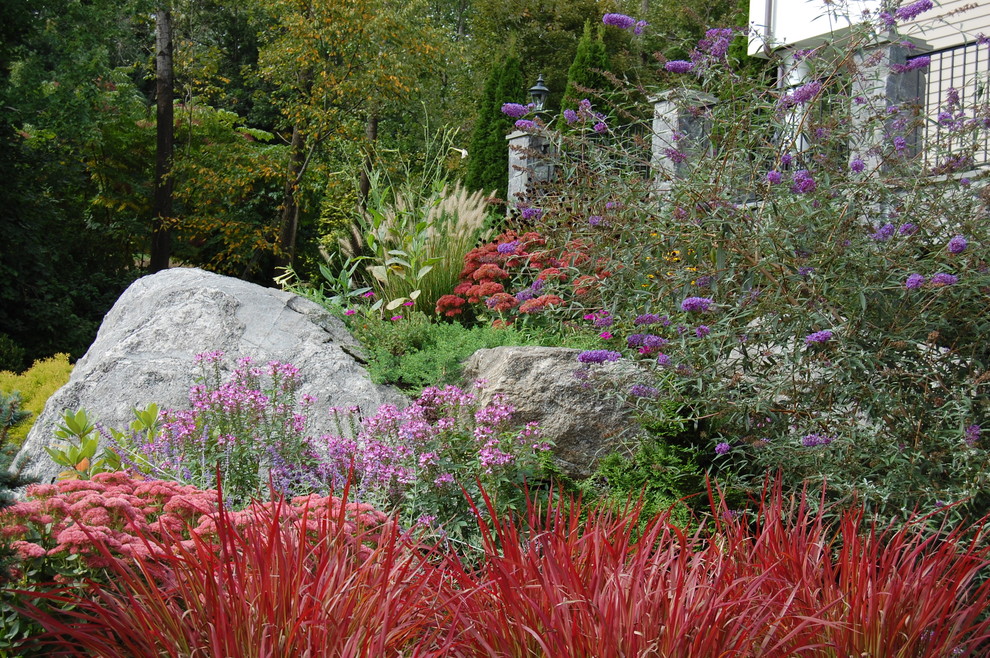 Exempel på en eklektisk trädgård i slänt