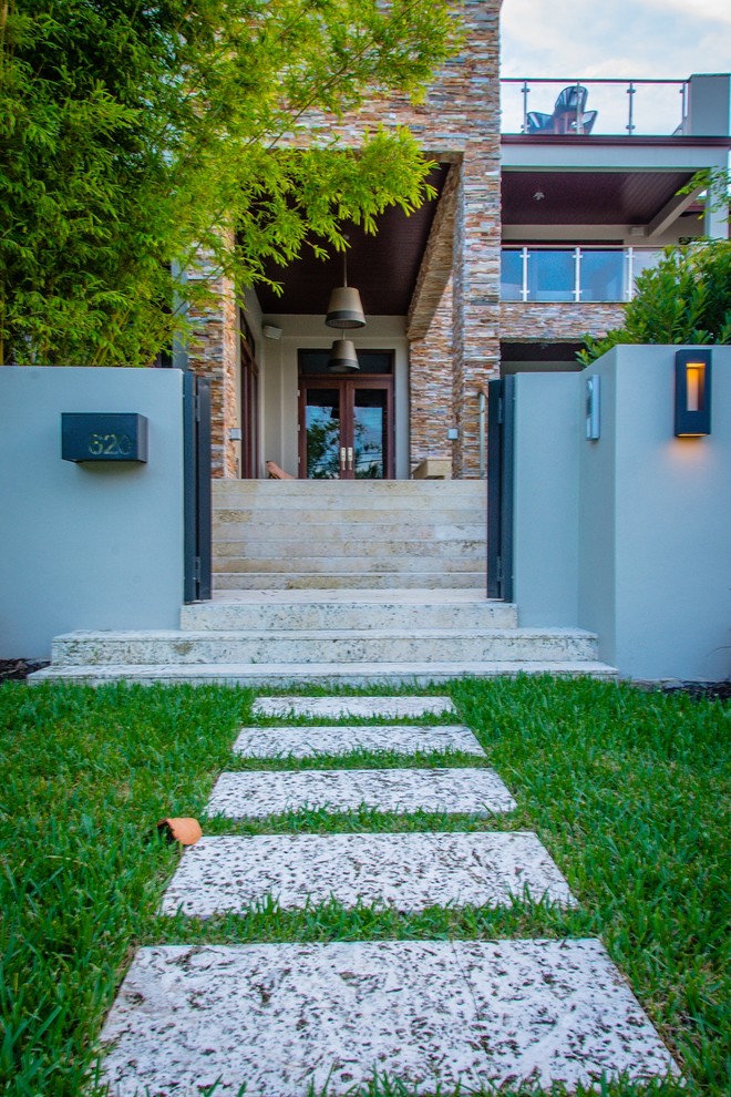 Inspiration for a medium sized modern front partial sun garden in Miami with a garden path and natural stone paving.