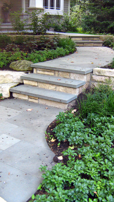 Medium sized classic front partial sun garden for summer in Chicago with natural stone paving and a retaining wall.