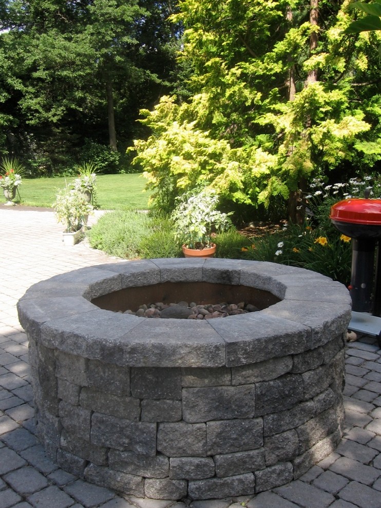 Aménagement d'un jardin classique avec des pavés en pierre naturelle.