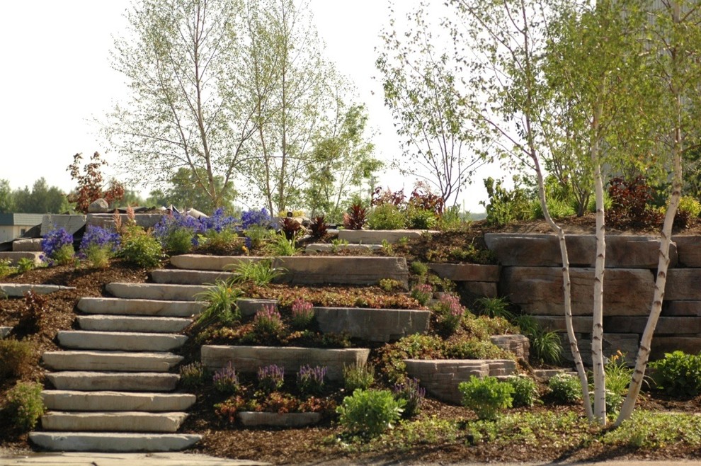 Пример оригинального дизайна: участок и сад в классическом стиле с подпорной стенкой и покрытием из каменной брусчатки