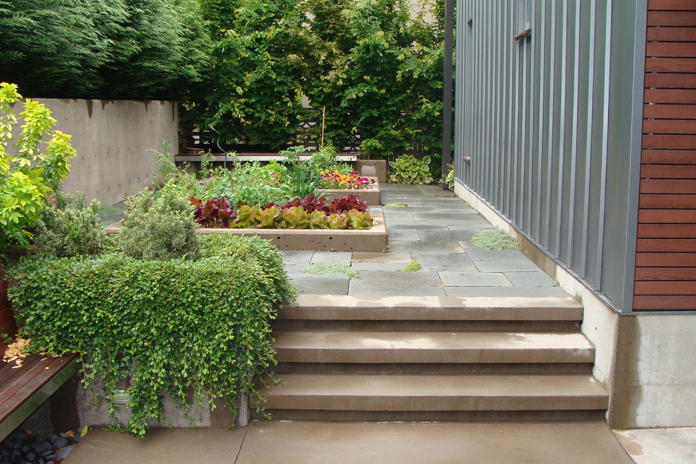 Ejemplo de jardín moderno grande en patio lateral con huerto, jardín francés, exposición total al sol y adoquines de piedra natural