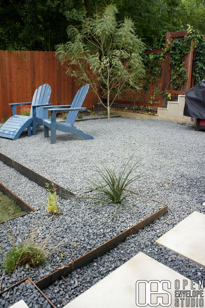 Design ideas for a small modern partial sun backyard gravel retaining wall landscape in Austin.