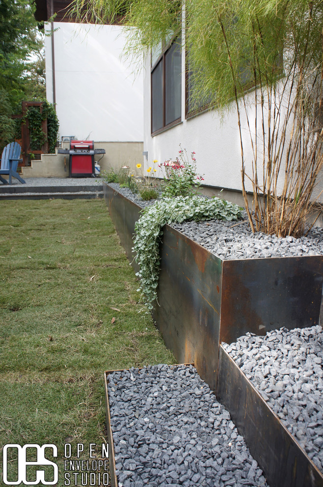 Стильный дизайн: маленький участок и сад на заднем дворе в стиле модернизм с подпорной стенкой, полуденной тенью и покрытием из гравия для на участке и в саду - последний тренд