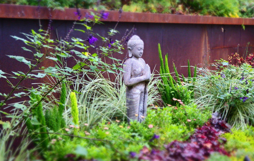 Kleiner, Halbschattiger Asiatischer Garten im Sommer, hinter dem Haus mit Steindeko und Flusssteinen in Sacramento