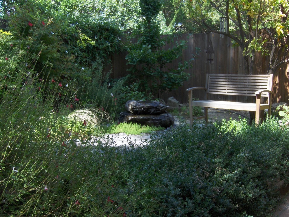 Imagen de camino de jardín mediterráneo de tamaño medio en primavera en patio trasero con adoquines de piedra natural, jardín francés y exposición reducida al sol