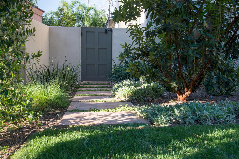 This is an example of a mid-sized mediterranean front yard brick landscaping in Los Angeles.