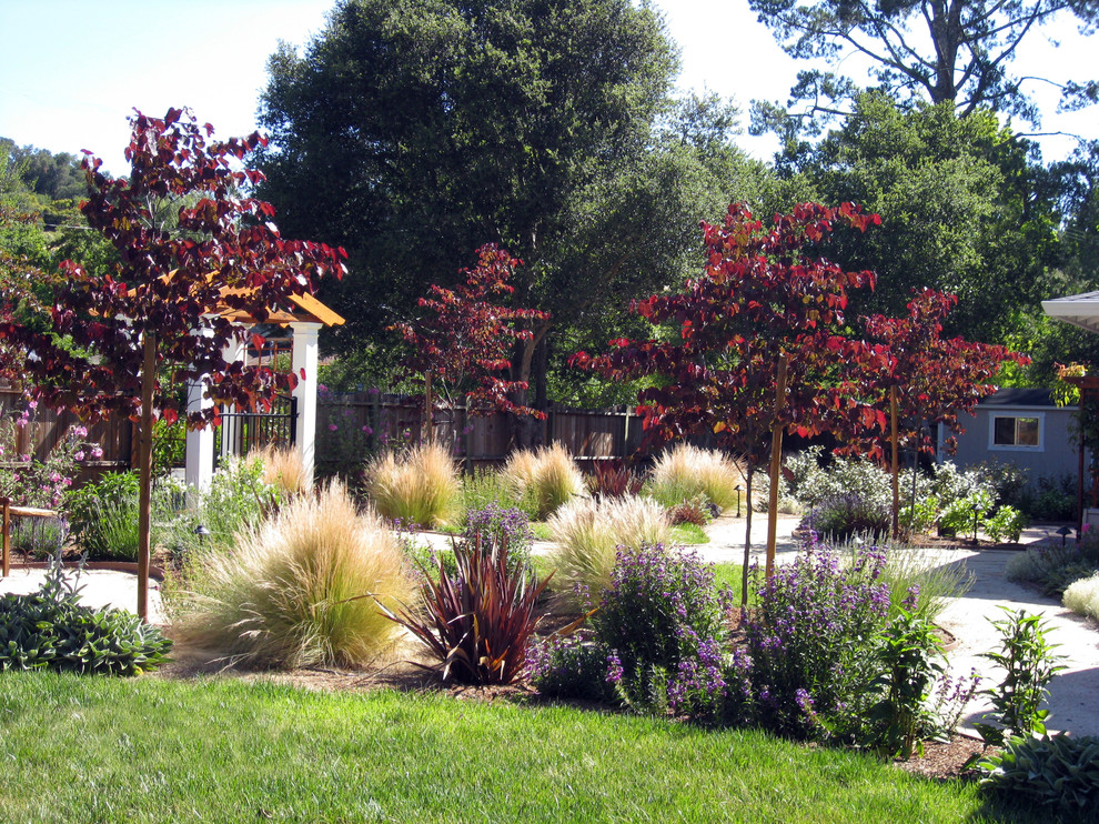 Пример оригинального дизайна: огромный солнечный, весенний участок и сад на переднем дворе в средиземноморском стиле с садовой дорожкой или калиткой, хорошей освещенностью и покрытием из каменной брусчатки