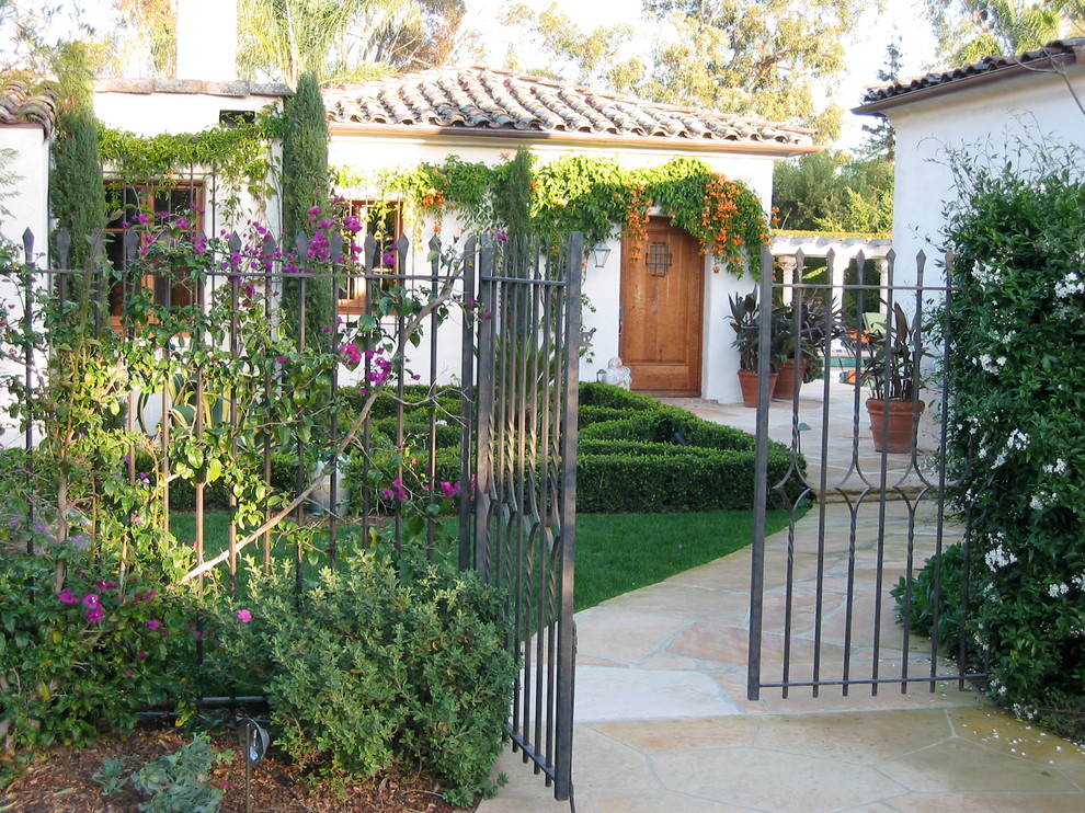 Photo of a mediterranean garden in Santa Barbara with natural stone paving and an outdoor sport court.