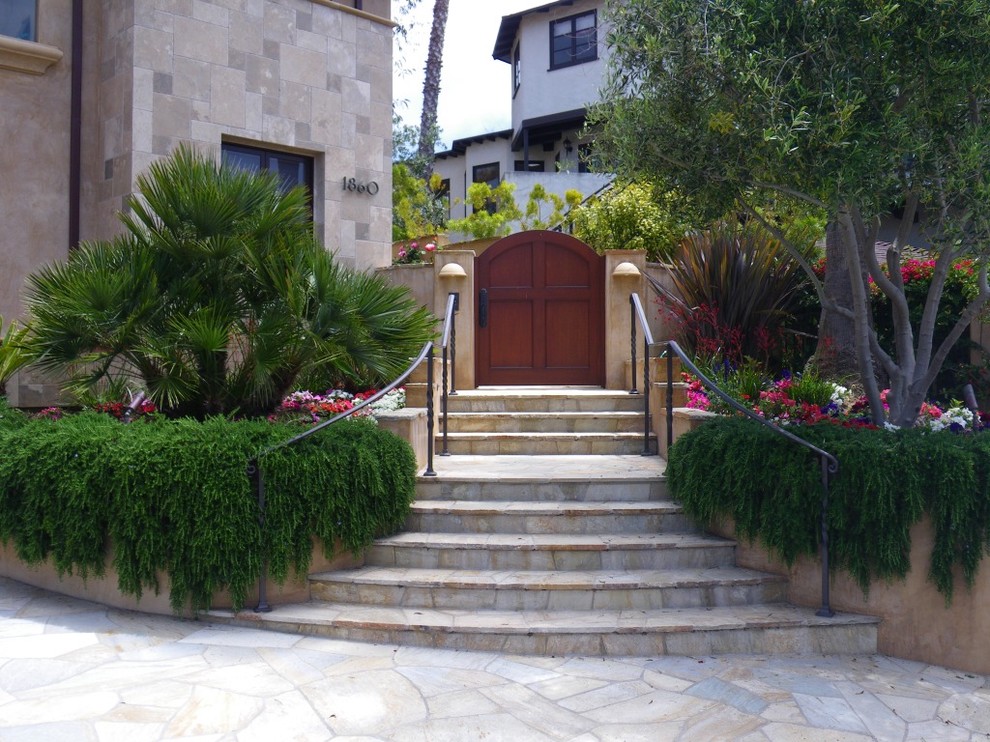На фото: участок и сад на склоне в средиземноморском стиле с покрытием из каменной брусчатки с
