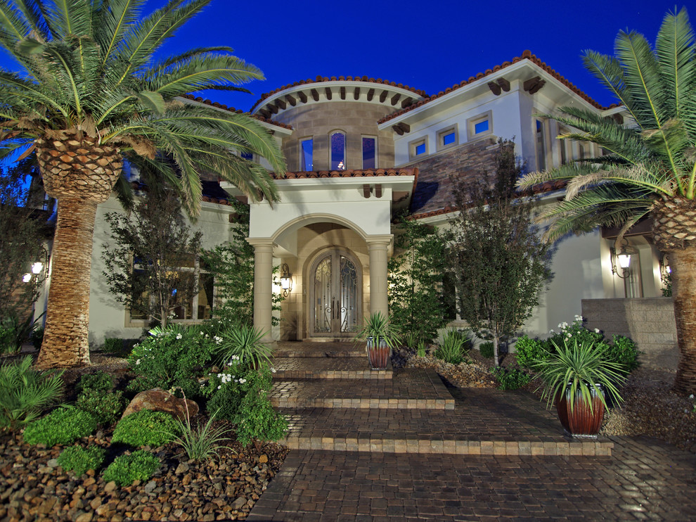Photo of a mediterranean front garden in Las Vegas with a potted garden and natural stone paving.
