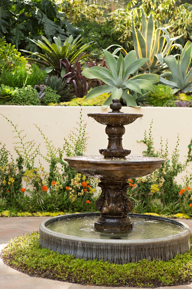 На фото: солнечный садовый фонтан в средиземноморском стиле с хорошей освещенностью