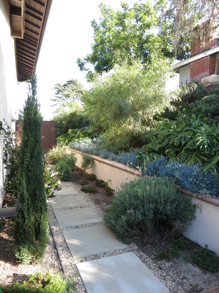 На фото: тенистый, летний участок и сад среднего размера на боковом дворе в средиземноморском стиле с подпорной стенкой и покрытием из гравия