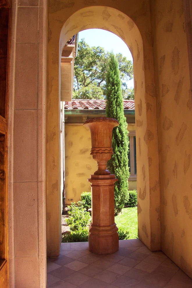 Immagine di un grande giardino mediterraneo esposto a mezz'ombra davanti casa in estate con pavimentazioni in pietra naturale