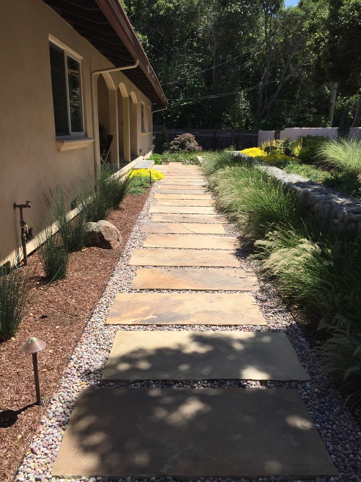 Medium sized world-inspired front xeriscape partial sun garden for spring in San Francisco with a water feature and natural stone paving.