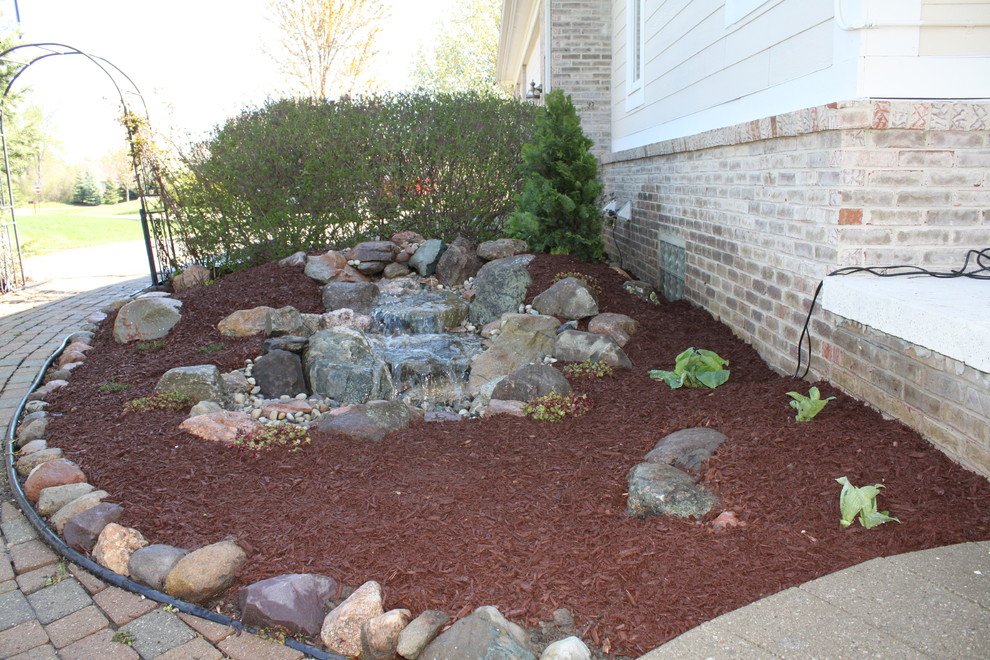 Inspiration for a mid-sized rustic shade backyard mulch water fountain landscape in Detroit.