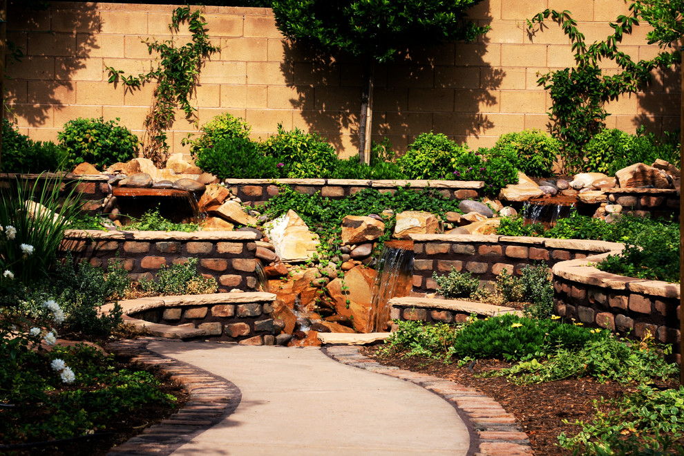 Esempio di un giardino formale chic esposto in pieno sole di medie dimensioni e dietro casa in primavera con fontane e pavimentazioni in pietra naturale