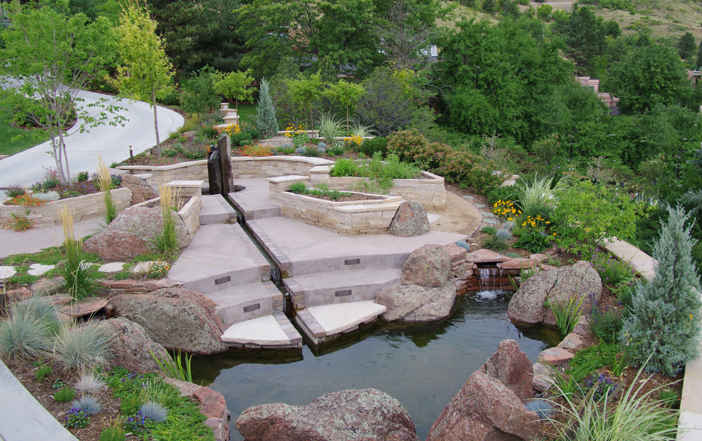 Diseño de jardín actual en ladera con roca decorativa