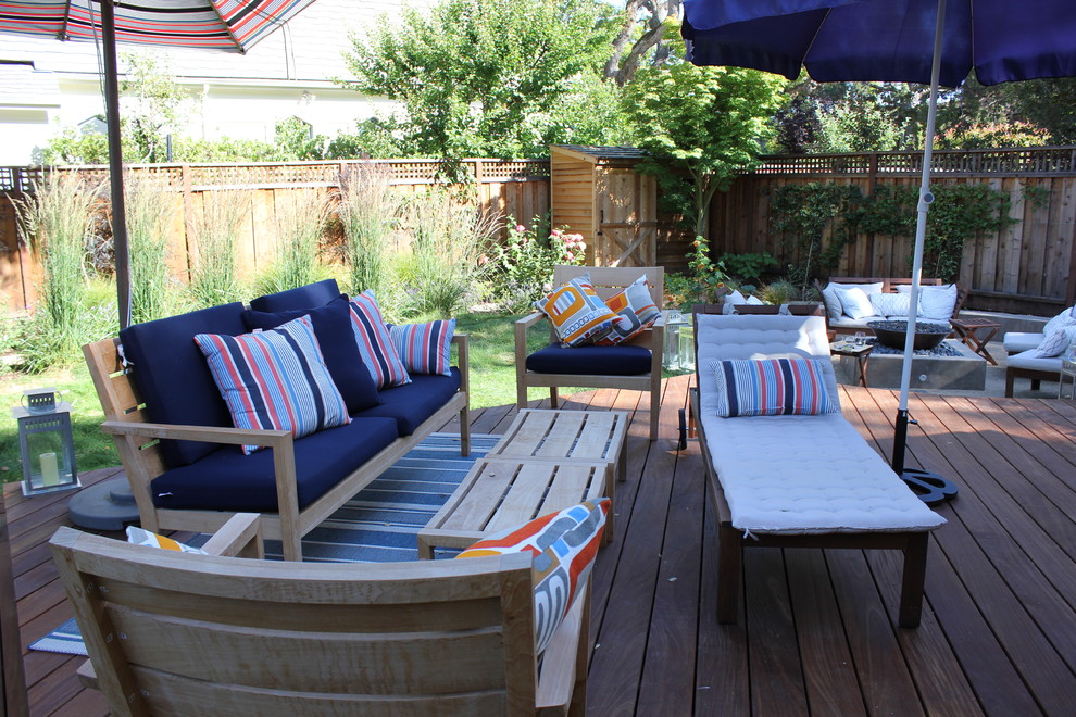 This is an example of a mid-sized coastal shade backyard landscaping in San Francisco with a fire pit and decking for spring.