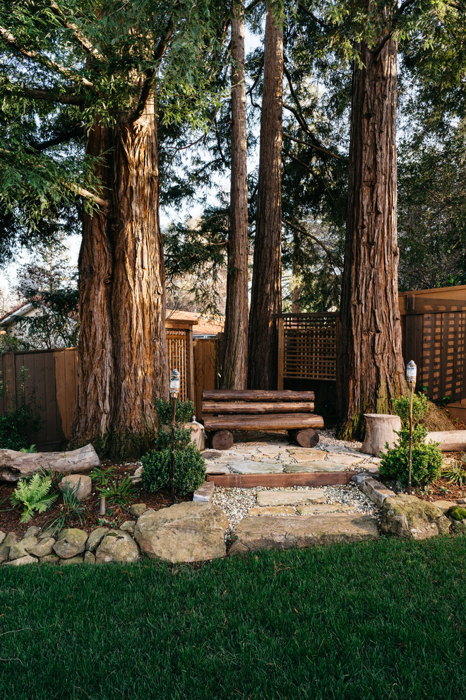 Cette image montre un jardin chalet avec une exposition ombragée et des pavés en pierre naturelle.