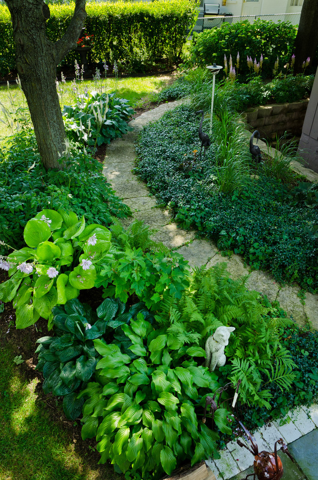 Ispirazione per un giardino tradizionale in ombra di medie dimensioni e dietro casa in estate con un ingresso o sentiero e pavimentazioni in pietra naturale