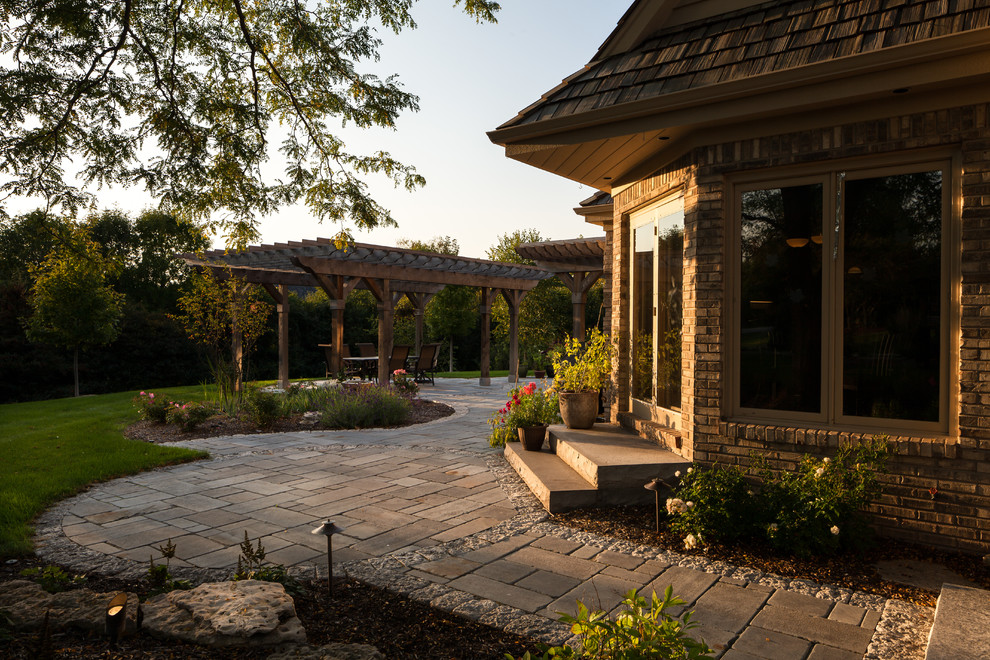 Стильный дизайн: большой солнечный участок и сад на заднем дворе в классическом стиле с хорошей освещенностью и покрытием из каменной брусчатки - последний тренд