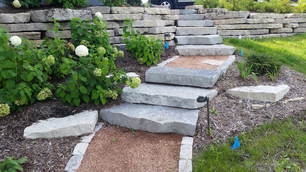 Photo of a contemporary back garden in Milwaukee with a garden path and natural stone paving.