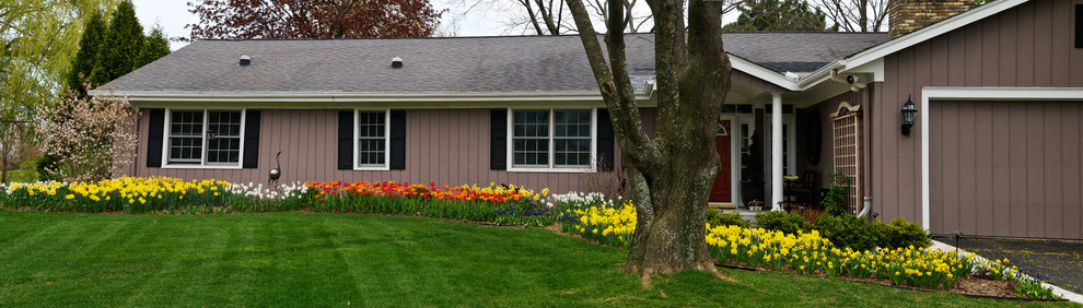 Foto di un'aiuola tradizionale esposta a mezz'ombra di medie dimensioni e davanti casa in primavera con pacciame
